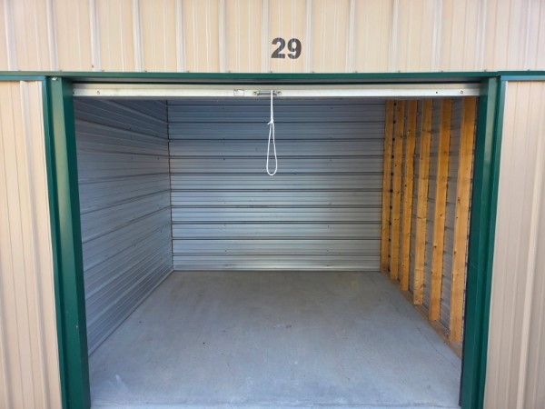 Interior of 10x10 storage unit number 29 showing clean concrete floor, metal walls, and wood-framed studs