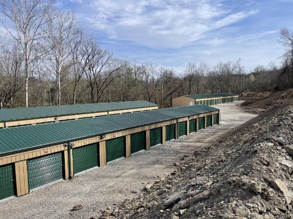 Exterior view of U.S. 60 West Storage LLC storage buildings along a hillside with a tree line in the background